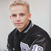 Luke poses in a black leather jacket.