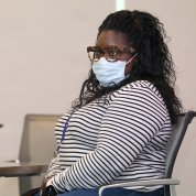 Black woman in face mask seated at conference table