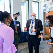 Elam, Chiang, Tabak and Nwanyanwu chat informally. All are wearing masks.