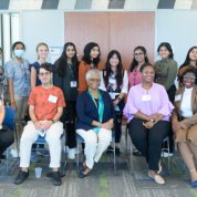 Group photo with panelists seated and students standing behind them.