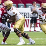 College football game play. Johnson blocks for running back.