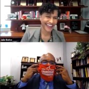 Johnson puts on a University of Alabama cloth mask while Berko smiles