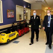 Levine and Tabak stroll through a toy-car-lined hallway