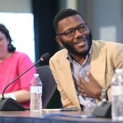 Seated at long table, Morgan watches as McCullough speaks