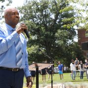 Johnson in suit and tie talks into microphone