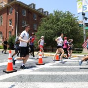 Several rows of runners navigate around orange cones.