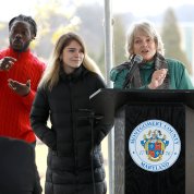 sign language interpreter, Alperson's daughter, and Alperson's wife stand before the assembly.