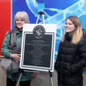 Wife and daughter flank the plaque marking “Phil Alperson Way