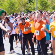 At the start line, runners of the next leg reach out fists or elbows.