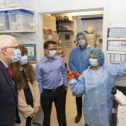 Sharma speaks to a small group of people in a lab