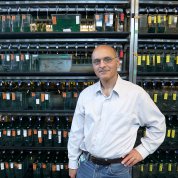 Weinstein stands in front of a rack holding rows of zebrafish tanks.