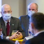 Gilman and Kilmarx, seated, talk with the minister.
