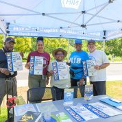 Four employees hold up posters for the Health & Wellness Expo