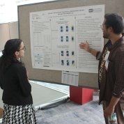 Rajen points to his poster with scientific facts and figures as Mendez-Santos looks on