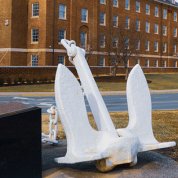 White anchor on platform with plaque with NIH's Building 3 in background.