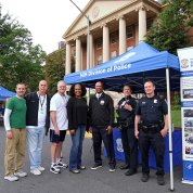 NIH Police officers and bike club members pose together under tent by Bldg. 1 pitstop