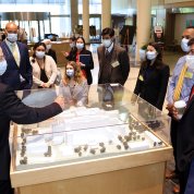 Gilman, surrounded by the fellows, points to the CC model in the atrium.