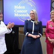 With Biden Cancer Moonshot title slide projected behind them, Bertagnolli gestures toward Haydon and Biden.