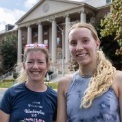 The top two female finishers smile in front of Building One. 