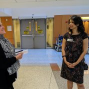 Sofranko, at left, holding a folded piece of paper, speaks with Wolek. The two are standing in the Clinical Center hospital lobby.