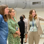 Woman explains her research poster to colleagues
