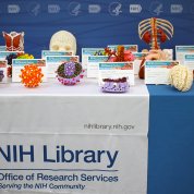 Table with NIH Library drape features several colorful objects and models