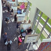Seen from above, people standing in front of posters, chatting