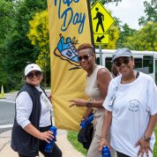 Three ladies by Take a Hike flag banner