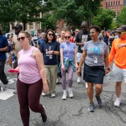 A group of people congregate to walk, colorful clothes