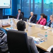Large conference table with men and women seated around it.