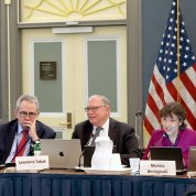 several people seated at a conference table, smiling
