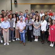 A large group of people posing for a photo in a conference room.