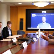 Reed and IC directors sit at a conference table. The meeting is virtual.