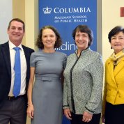 Three women and one man smile with Columbia Mailman School of Public Health logo behind them.
