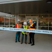 Outside the building, a man holds big scissors to ribbon that reads: Rocky Mountain Comparative Medicine Center - Building 34