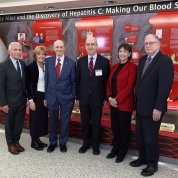 A group photo featuring Alter in front of the exhibit