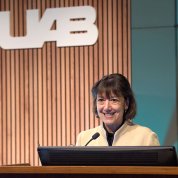 Bertagnolli smiling at podium with UAB logo backdrop