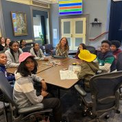 Schwetz sits at a table surrounded by kids, papers and markers in Wilson Hall.