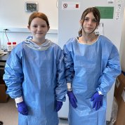 Two girls dressed in scrubs and rubber gloves