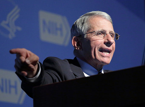 Dr. Fauci talks at podium while pointing a finger