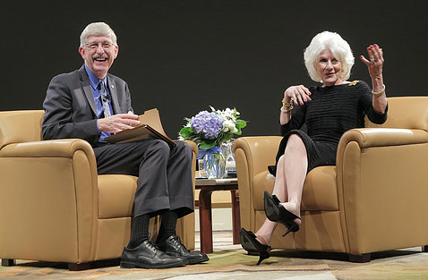 Collins and Rehm, seated on stage, smile as they interact with the audience.