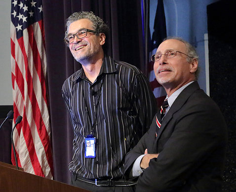 A smiling Pérez-Stable stands with Robert Lembo at the podium