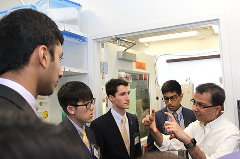 Dr. Kapil Bharti holds up an ocular stem cell for students in an NEI lab