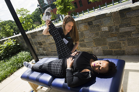 A therapist stretches a patients' hamstring