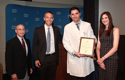 Dr. Bilusic holds plaque, with three other doctors.