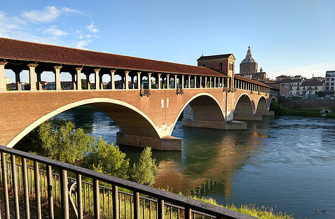 A stone and brick arch bridge over the Ticino River in Pavia, Italy