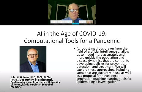 A screen shot shows Holmes speaking at the virtual lecture over his introductory slide that reads: AI in the Age of Covid-19.