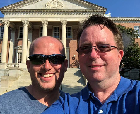 Chris and Jason Plummer smile as they pose in front of Bldg. 1 on NIH's campus.
