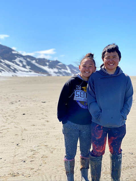 Two members of the Yup’ik community in Alaska, standing outside near mountains