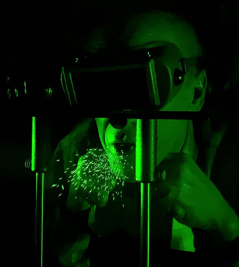 Under green laser light, a mist of droplets is expelled from the speaker's mouth.